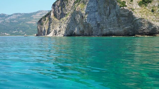 RT Dubovica Rocks near Buljarica and Svetac Rock, Montenegro. Stones, inaccessible rocks. Flysch marine lithological layers. Adriatic Mediterranean sea blue water. Nature park Katici. District Budva