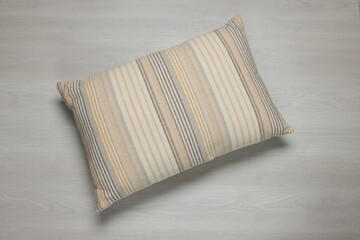 One decorative pillow on wooden background, top view