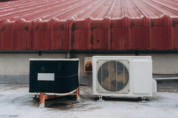 Air conditioner compressor is set up on the roof, along with big cooling units and air vents.