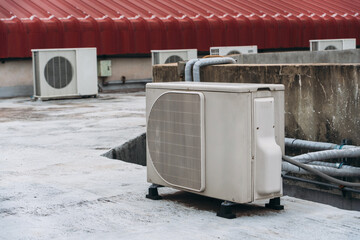 Air conditioner compressor is set up on the roof, along with big cooling units and air vents.