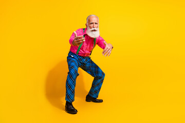 Full body photo of retired man dancing good mood dressed pink shirt vintage plaid pants fancy clothes isolated on yellow color background