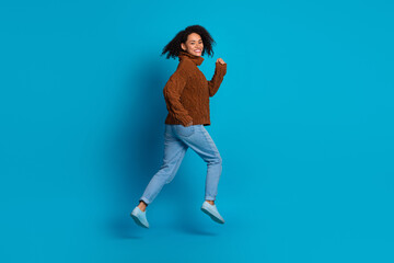 Portrait of a young woman in casual clothing against a blue background showcasing happiness and style