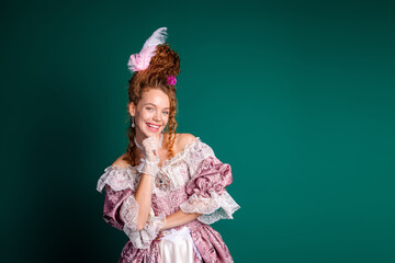 Elegant young woman in elaborate pink baroque dress against a green backdrop exuding historical...