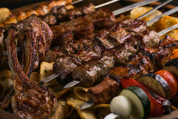 Assorted delicious grilled meat with vegetables sizzling over the coals on barbecue