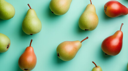 A flat lay of fresh pears arranged on a mint-colored surface, highlighting their green color and smooth texture.