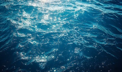 Fototapeta premium Sunlight dancing on deep blue ocean waves creating sparkling reflections and patterns