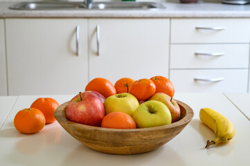 Cooking a healthy food or a breakfast. A bowl of fruits on the table.