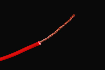 Red stripped electrical wire on black background, closeup