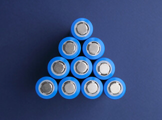 Many AA cell batteries on blue background, top view