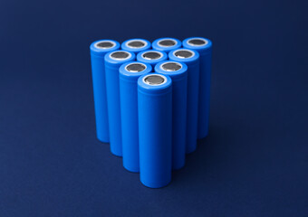 Many AA cell batteries on blue background, closeup