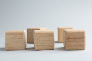 Blank wooden cubes on light grey background, closeup