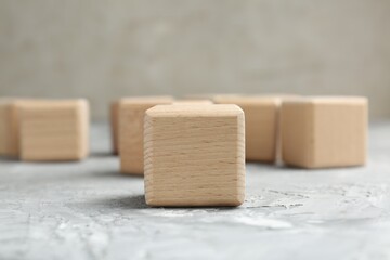 Blank wooden cubes on grey textured table, closeup