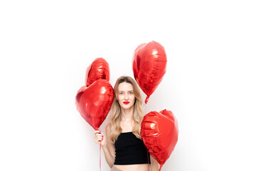 happy smiling young woman with red lipstick and red heart shaped balloons