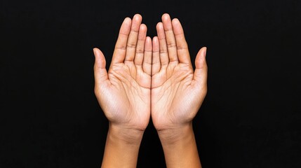 Two open hands palms together on black background.  Possible use  Stock photo for prayer, gratitude, or charity concept