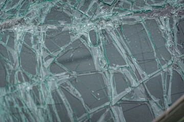Broken glass, smashed windshield after a car accident, ruined front of a passenger car, insurance after a road collision and accident