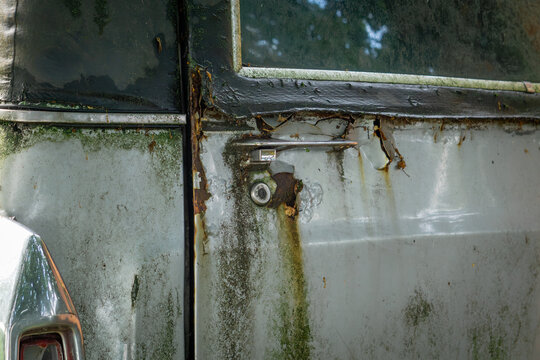 old antique, classic hearse, funeral car for transporting bodies. rust on the car, green mold infiltrates, rotten sheet metal, devastation.