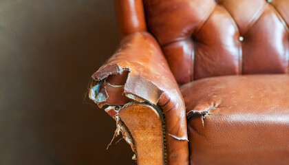 Obraz premium Old torn leather armchair. Distressed vintage home furniture.