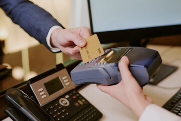 Medium close up of unrecognizable male hand tapping golden card while unrecognizable female...