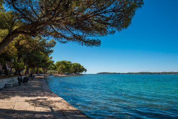 Küstenstreifen mit Promenade und azurblauem Meer in Fazana, Kroatien