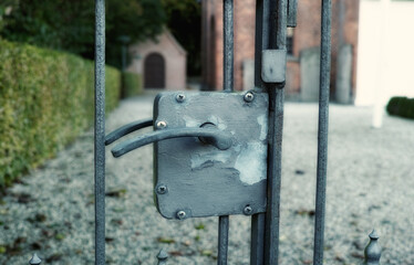 Gate, metal lock and security for safety, protection or outdoor driveway with restriction. Iron, vintage barrier or handle closeup at property for privacy, entrance access or fence with road at home