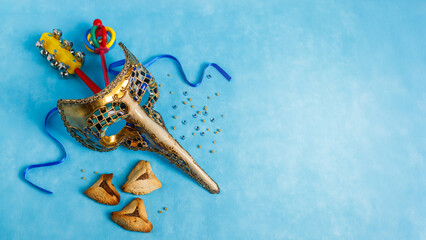Carnival attributes and тraditional jewish sweets hamantaschen cookies. Turquoise background. Holiday Purim