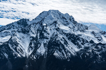 Obraz premium Beautiful Snow Capped Mountains with cloudy blue skies in the Himalayas of Nepal