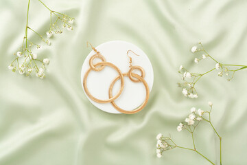 Elegant golden jewelry with decoration on textile background, top view