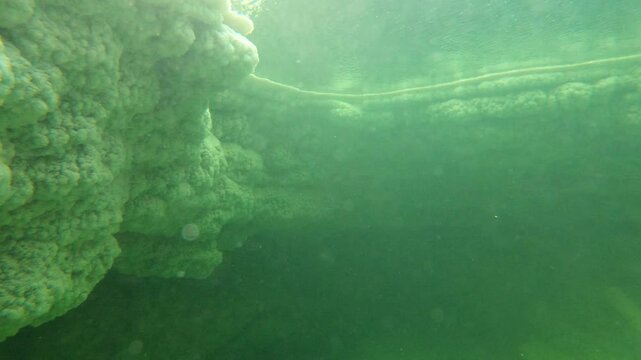 Underwater (GoPro) shot of thick chunks of salt in the Danakil desert in Ethiopia, surreal natural landscape in Africa
