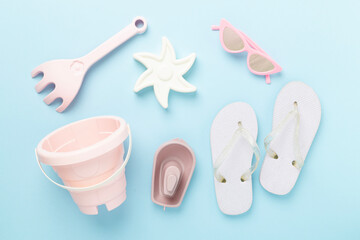 Children's flip-flops and beach toys on color background,,top view