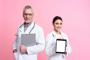 Portrait of smiling male and female doctors with stethoscopes holding clipboard and white box...
