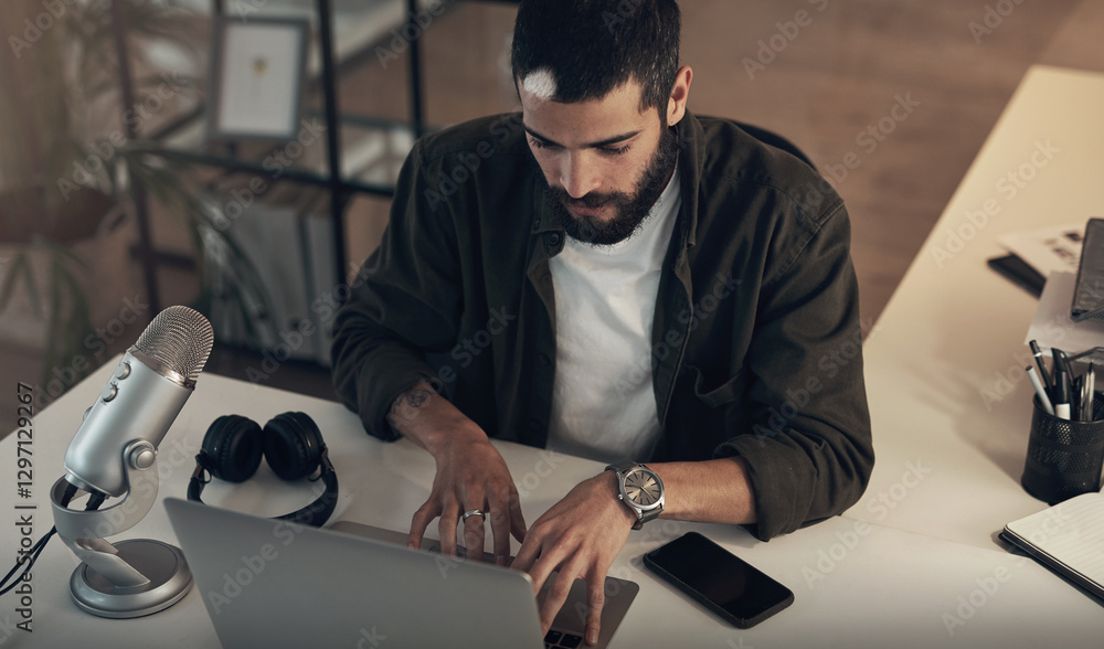 Poster Laptop, podcast and typing with man in office at night for upload to streaming site or website. Computer, microphone and update with employee at desk in workplace for video editing from above