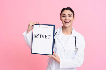 Portrait of smiling female doctor with stethoscope holding diet sign on clipboard isolated.
