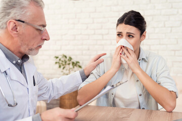 Doctor with stethoscope and female patient in office. Doctor is comforting woman.