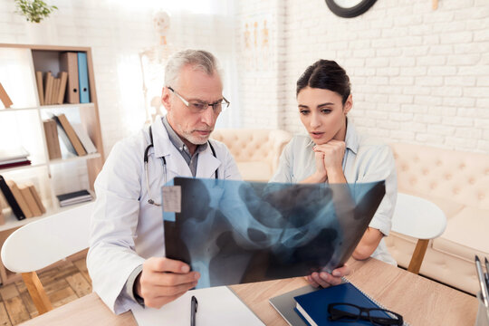 Doctor with stethoscope and female patient in office. Doctor is showing x-ray to patient. - Powered by Adobe