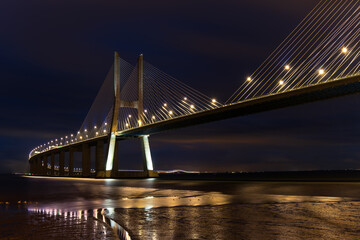 The illuminated Vasco da Gamma Road Bridge in the Portuguese capital Lisbon in the blue hour just...