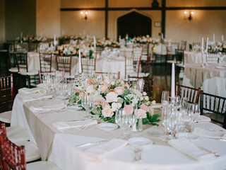 Elegant dining setup featuring floral arrangements in a banquet hall during an event celebration
