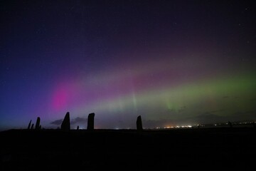 Northern lights in the twilight over the ring of brodgar in orkney
