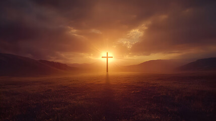 Sunset silhouette of a cross against a dramatic sky in a rural landscape
