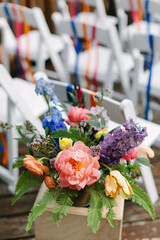 Colorful floral arrangement beside empty chairs at an outdoor event venue during a spring celebration