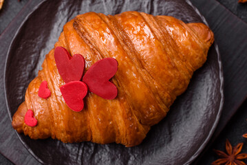 Sweet crispy croissant decorated with red hearts