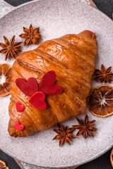 Sweet crispy croissant decorated with red hearts