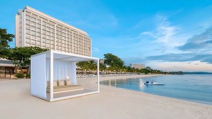 Obraz premium Modern Beach Cabana with Scenic View of Calm Water and Hotel at Dusk