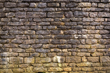 Rustic stone wall with irregular brown rocks and white mortar, creating a textured architectural background.