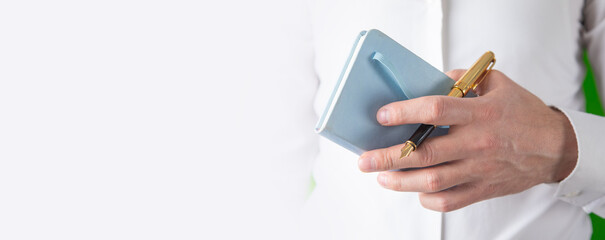 Man holding notepad with a pen.