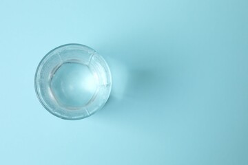 Transparent glass with water on blue background. Drinking clear water in the morning for health