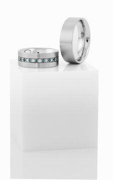 Wedding rings on top of white pedestal.
