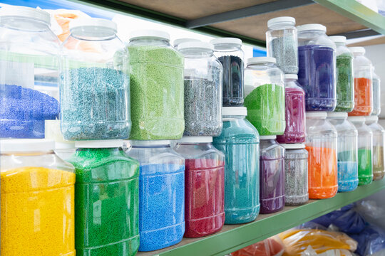 Color grains of plastic in containers used for high pressure plastic molding.