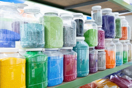 Color grains of plastic in containers used for high pressure plastic molding.