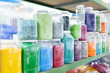 Color grains of plastic in containers used for high pressure plastic molding.