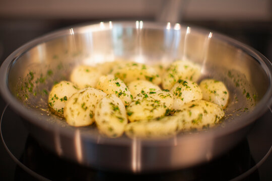 Potatoes with herbs in a frying pan.